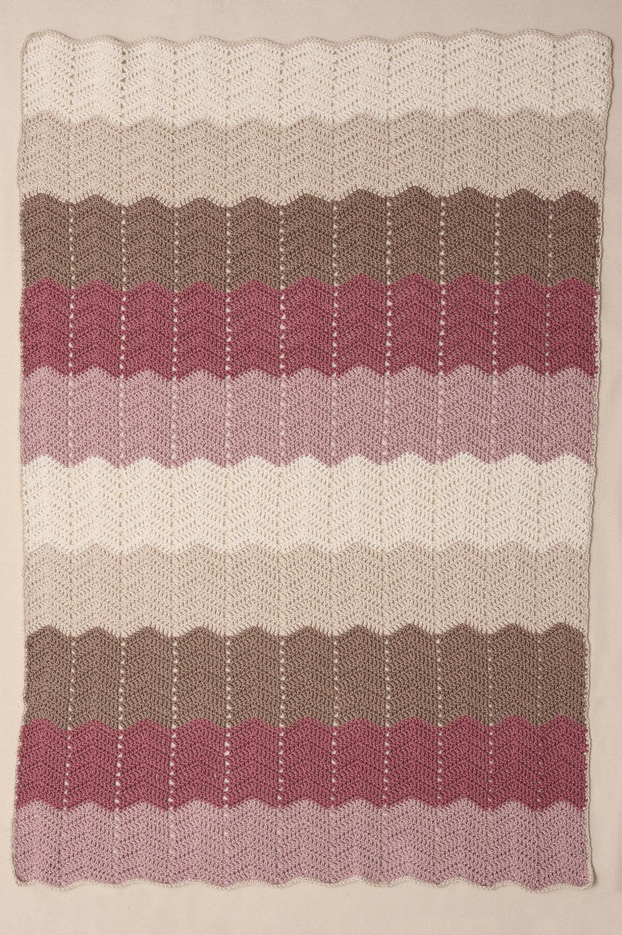 Hæklet babytæppe med zigzagstriber i råhvide, beige, brune og rosa nuancer, hæklet i Anyday Cotton 8/4 Colorbag fra Mayflower.