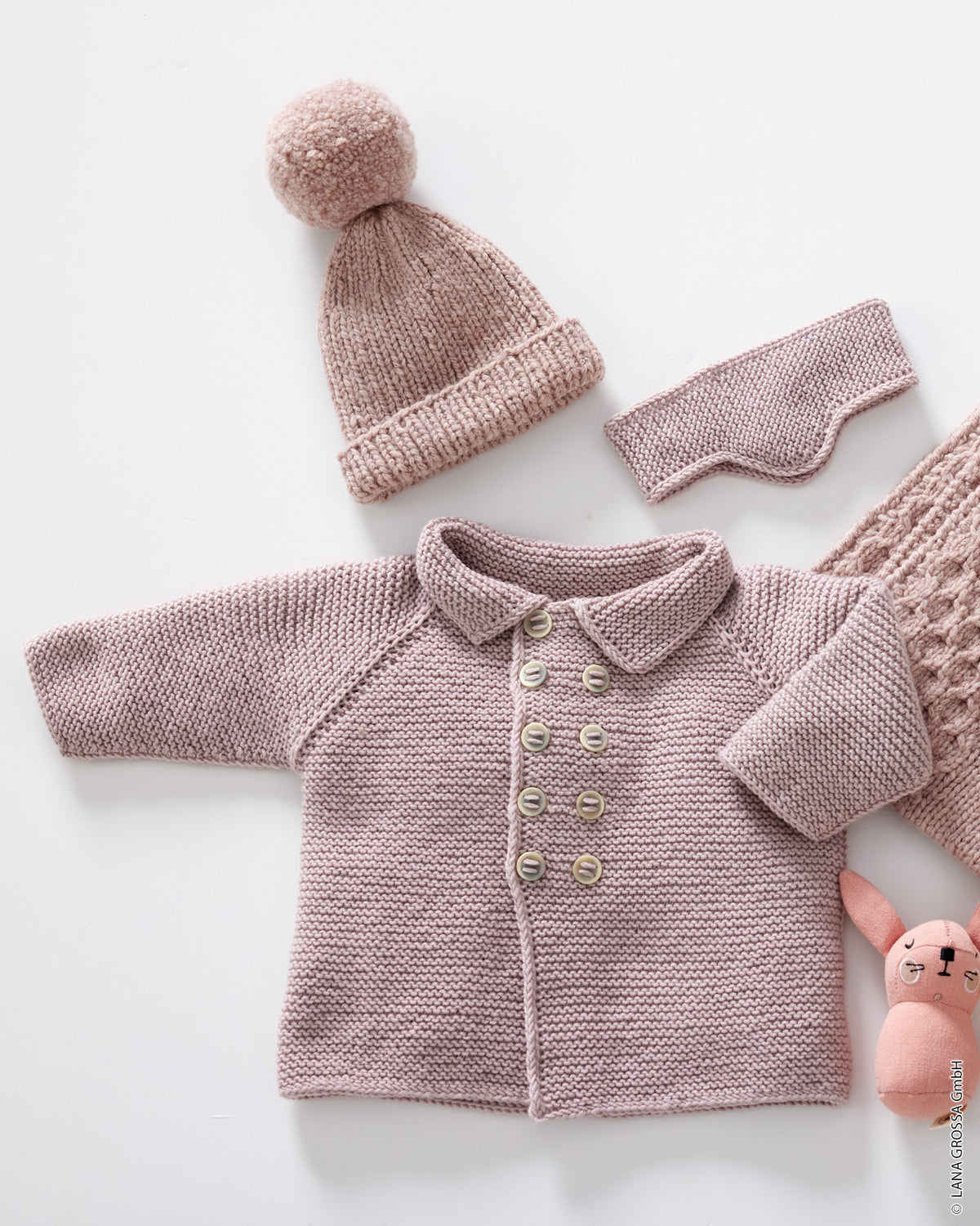 Baby i strikket frakke med krave, raglanærmer og dobbeltradet knaplukning i Cool Wool Big fra Lana Grossa i farven Rosentræ (953).