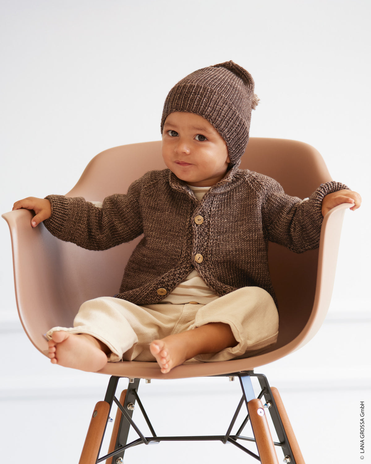 Babyjakke i Cool Wool Big fra Lana Grossa med raglan og kontrastfarvede albuelapper